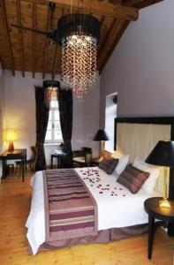 - une chambre avec un grand lit et un lustre dans l'établissement The Library Hotel Wellness Retreat, à Kalavasos