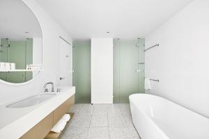 布里斯本的住宿－藝術系列酒店- 約翰遜，白色的浴室设有浴缸和水槽。