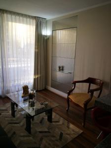 a living room with a glass table and a chair at Austral Rentahome Republica Árabe de Egipto in Santiago