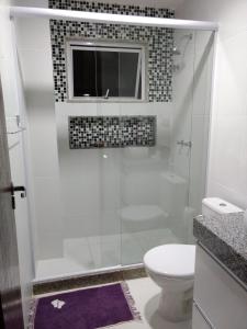 a bathroom with a shower with a toilet and a window at Apartamento Novo em Itaúna, Maracanã do Surf in Saquarema