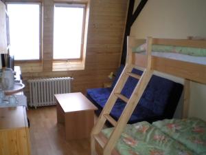 - une chambre avec 2 lits superposés et une table dans l'établissement Hotel Vltava, à Strážné