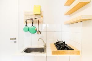Kuchyň nebo kuchyňský kout v ubytování Simply Minimalist 2BR The Springlake Summarecon Apartment By Travelio