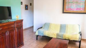 sala de estar con silla y TV en E14 Estrella Center of Tamarindo 3bed+2bath, en Tamarindo