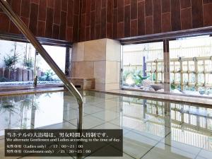 a swimming pool in a building with windows at S.Training Center Hotel Osaka in Osaka