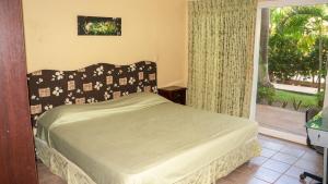 タマリンドにあるLC4 La Cometa Center of Tamarindo 1bed+1bathのベッドと大きな窓のある寝室