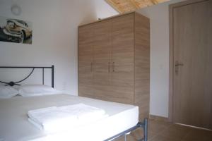 a bedroom with a bed and a large wooden cabinet at Villa Elpiniki in Troulos