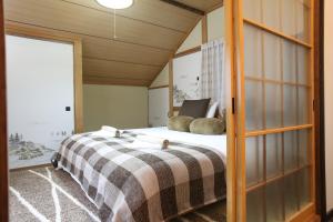 1 dormitorio con 1 cama con 2 almohadas en Powder Peak Misorano Free courtesy car en Hakuba