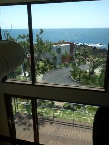 a view of the ocean from a window at Sun Village in Seogwipo