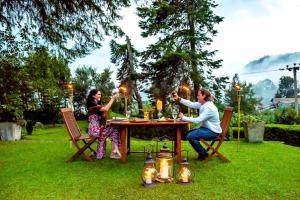 a man and woman sitting at a table with candles at Brockenhurst Bungalow in Nuwara Eliya