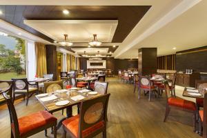 a dining room with tables and chairs in a restaurant at Aloha On The Ganges by Leisure Hotels in Rishīkesh
