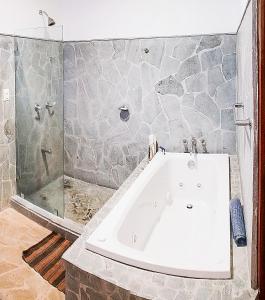 e bagno con vasca e parete in pietra. di CW3 Casa Wasabi 3bed+3bath a Tamarindo