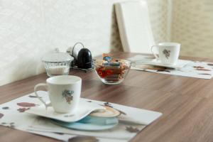 ノヴォシビルスクにあるCentral Apartment near by Hilton hotelの木製テーブルの上に置かれたカップ2杯
