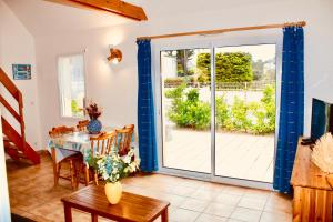 comedor con mesa y puerta corredera de cristal en Les Oiseaux, en Barneville-Carteret