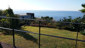 a view of the ocean from the balcony of a house at Sun Village in Seogwipo