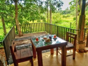 a table with a plate of food on a porch at Guruwaththa Eco Lodge in Hikkaduwa