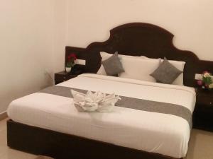 Un dormitorio con una cama grande con una flor. en Ebenezer Plaza, en Nedumbassery
