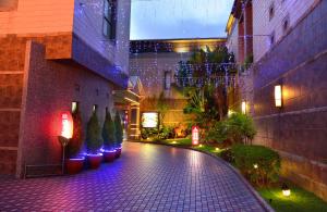 um pátio com plantas e luzes num edifício em Jing Hwa Motel em Tainan