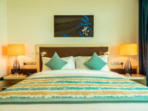 um quarto com uma cama grande e 2 candeeiros em Retaj Salwa Resort & Spa em Doha