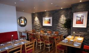 a restaurant with tables and chairs in a room at The White House in Kinsale