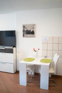 a kitchen with a white table and chairs and a tv at Apartment 1 Zimmer EG in Ratingen