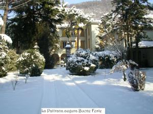 un cortile coperto di neve di fronte a una casa di La Patirana Guesthouse a Zandobbio