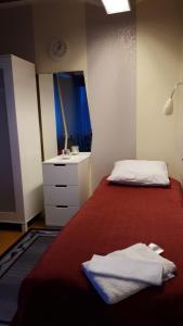 a bedroom with a bed and a dresser and a mirror at Dessans Café & Logi in Pello