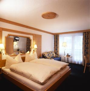 ein Schlafzimmer mit einem großen Bett in einem Zimmer in der Unterkunft Hotel Ambiente in Saas-Fee