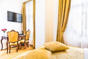 a bedroom with a bed and a table and a mirror at Charles Bridge Palace in Prague