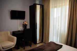 a hotel room with a bed and a chair and a mirror at Panoramic in Baia-Sprie