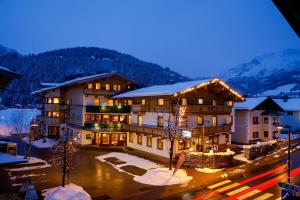 a large building in the mountains with snow on the ground at Hotel Edelweiss in Hochfilzen