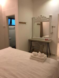 a bedroom with a bed with a mirror and towels at Brand New Apartment in Local Neighbourhood in Ringlet