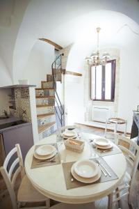 a dining room with a table and chairs and a staircase at Dimora Maestà in Putignano