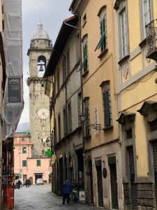 una strada cittadina con una torre dell'orologio in lontananza di Casa Cavour a Pontremoli