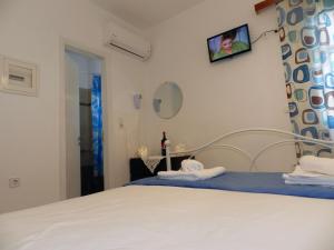 a bedroom with a white bed and a mirror at Aggelos Studios in Agios Prokopios