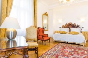 a bedroom with a bed and a table and a chair at Charles Bridge Palace in Prague