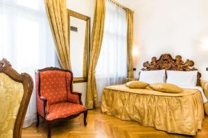 a bedroom with a bed and a chair at Charles Bridge Palace in Prague