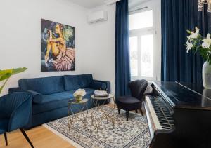 een woonkamer met een blauwe bank en een piano bij Pierrot & Pierrette in Zagreb