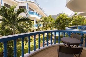 卡馬拉海灘的住宿－The Club Residence Kamala Beach，一个带桌椅的阳台和一座建筑