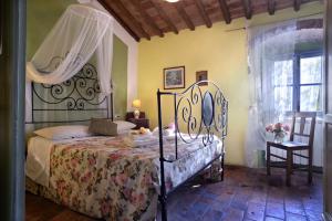 a bedroom with a bed with a wrought iron canopy at La Chiusuraccia in Barberino di Mugello