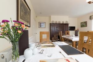 a dining room with a table with flowers in a vase at Whitethorn Bed and Breakfast in Congleton