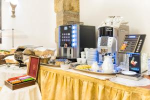 a table with food and a coffee maker on it at Charles Bridge Palace in Prague