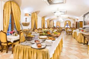 a long table with food on it in a restaurant at Charles Bridge Palace in Prague