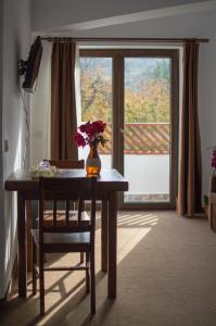 a vase of flowers on a table with a window at Pensiune Casa Ampeia in Alba Iulia