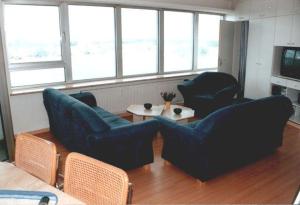 un soggiorno con 2 sedie blu e un tavolo di Ferienwohnung-im-Wikingturm a Schleswig