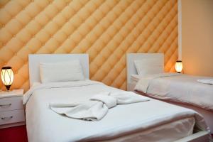 2 Betten in einem Schlafzimmer mit einem großen Kopfteil in der Unterkunft Vayk Hotel in Vaykʼ