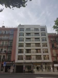 un gran edificio en una calle de la ciudad con en Aparto-Hotel Rosales en Madrid