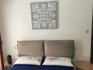 a bed with two pillows and a picture on the wall at Casa America in Montesilvano Marina