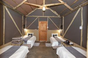 a room with four beds and a wooden door at Lapa Lange Game Lodge in Mariental
