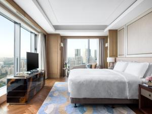 a bedroom with a large bed and a large window at The Langham, Hefei in Hefei