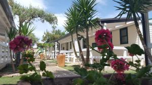 una casa con palme e fiori nel cortile di Residence "Il Faro" a Isola Capo Rizzuto